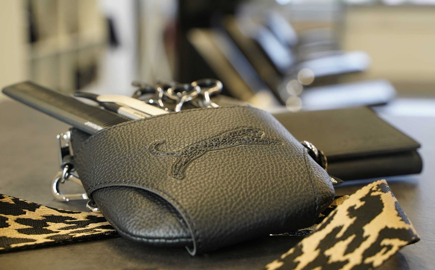 JAGUAR Crossbag and leather case in the salon – high-quality accessories for the safe storage of hairdressing scissors, combs, and tools, stylishly placed for tidiness, convenience, and quick access in everyday work.