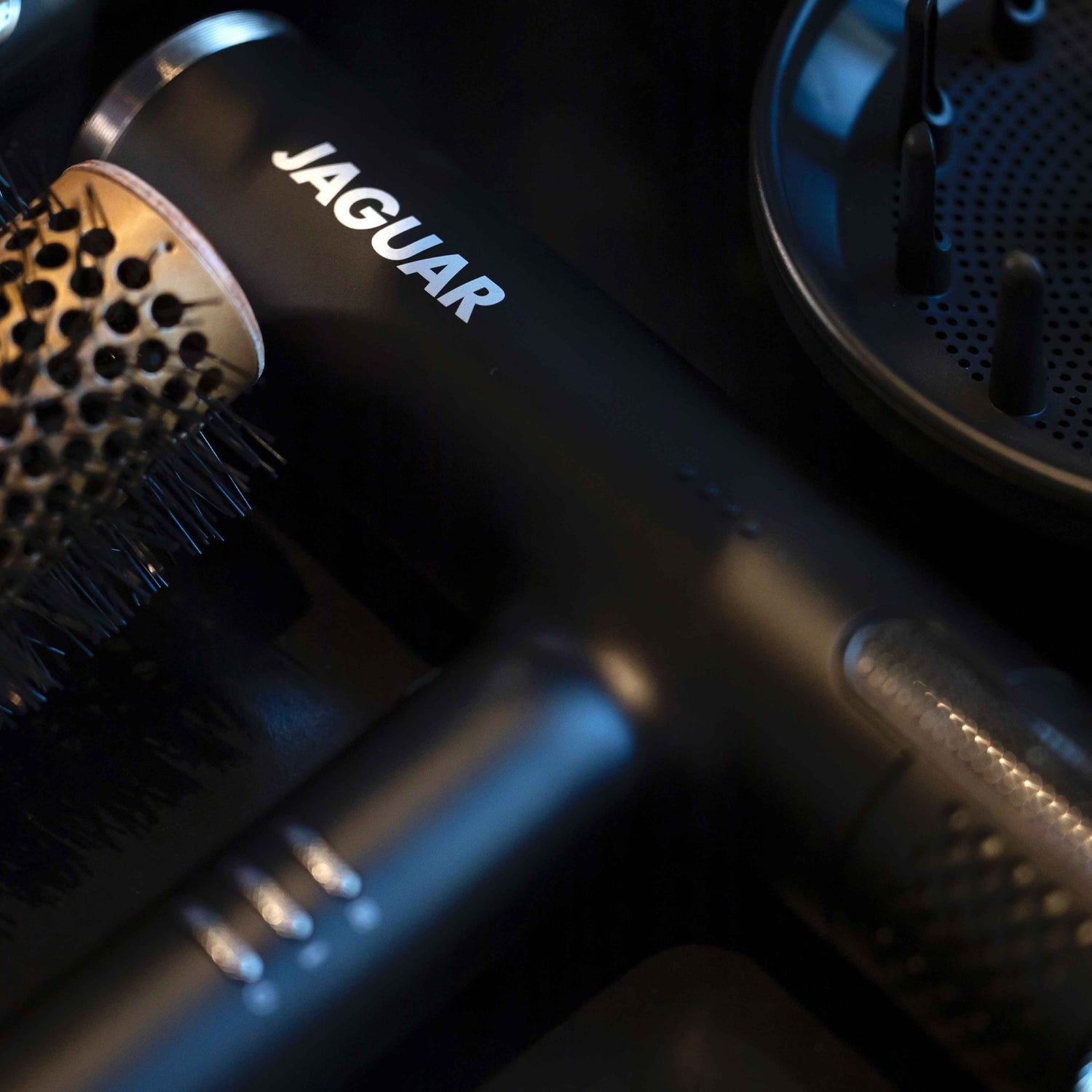 Close-up of the JAGUAR HD hair dryer with styling brush and diffuser attachment.
