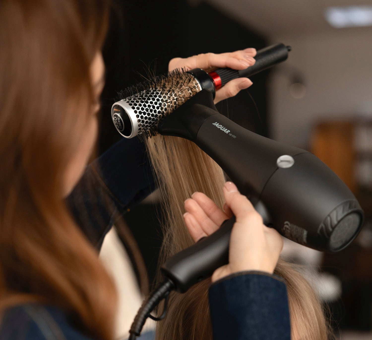 JAGUAR HD hair dryer in use for styling with a round brush, close-up in the salon