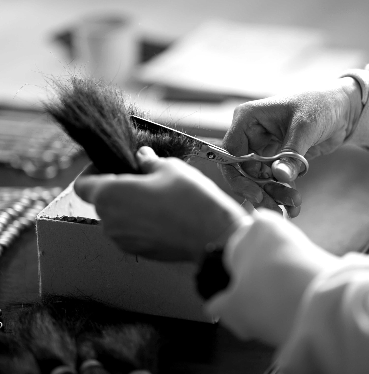 Black-and-white photograph: Quality control of JAGUAR hairdressing scissors during a cutting test on bundles of hair in the factory.