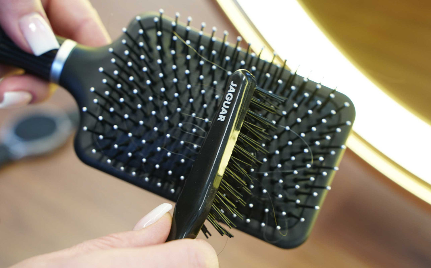 Cleaning brush for JAGUAR hairbrushes in use: Removing hair and residue between the bristles – for hygienic care, clean tools, and professional results in everyday salon life.