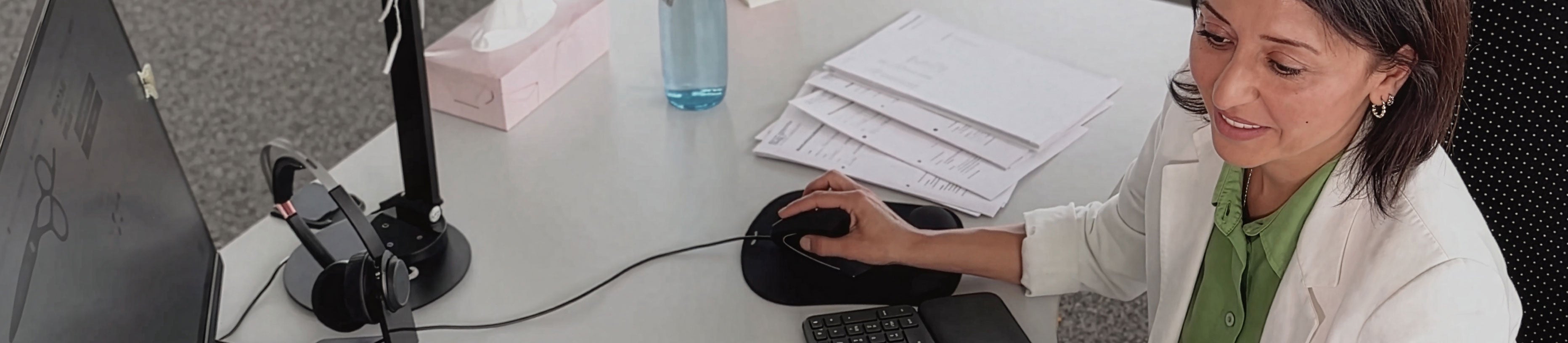 Employee answers customer inquiries at her desk – contact form and personal service at JAGUAR Solingen.