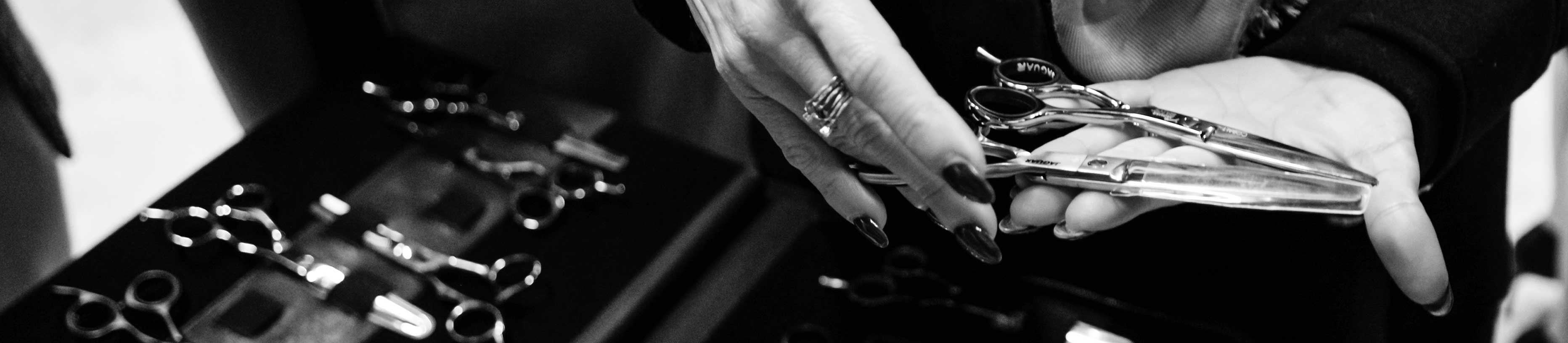 Hairdressers' hands hold various JAGUAR hairdressing scissors – overview of cutting techniques and scissor types in the scissors ABC.