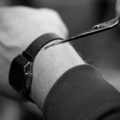 Une paire de ciseaux et un bras en noir et blanc.