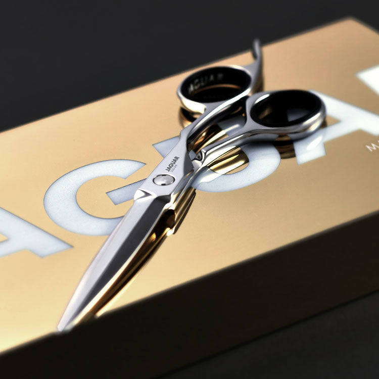 Gold Line hairdressing scissors Gold Line on a golden package against a dark background.